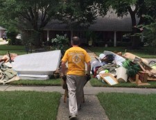 A Scientology Volunteer Minister carting debris out of a flood-damaged home