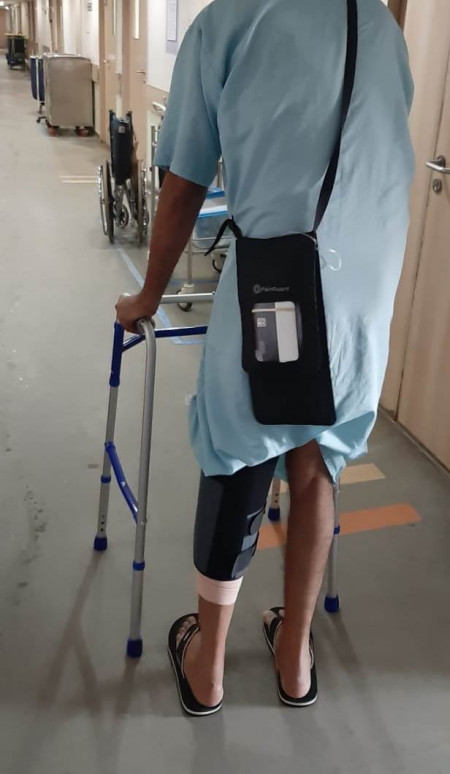 A patient is walking with the PainGuard™ pump