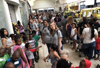 Krazy Coupon Lady employees and children stand in line for Build-A-Bear event