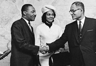 Dr. King and Mrs. King shake hands with Ralph Bunche at the United Nations