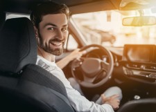 Friendly Driver Smiling from Front Seat of Car