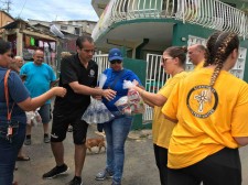 Volunteer Ministers help Jorge Navarro Suárez (in black) distribute supplies to his constituents.