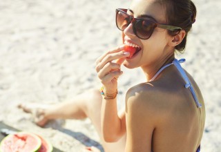 Woman Eating Watermelon on a Beach