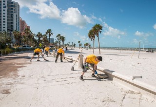 Scientology Volunteer Ministers, shoveling the sand off beachside sidewalks after Hurricane Irma struck Clearwater Beach.