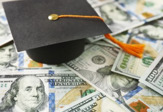 Graduation Cap Sitting on Hundred Dollar Bills