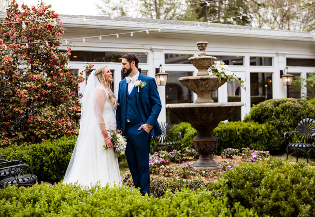 Bride and groom posting in garden courtyard at Primrose Cottage