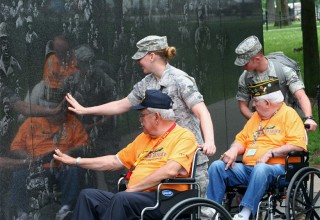 Service members escort WWII veterans at the National Mall in Washington