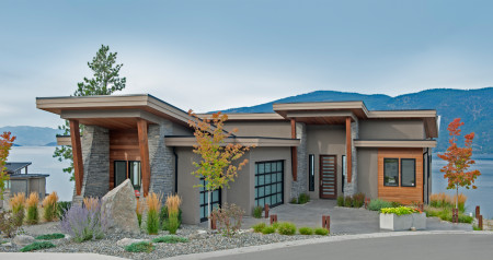 A house with a driveway and treesDescription automatically generated