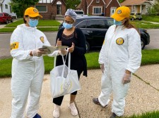 Dressed in their distinctive yellow caps and additional protective gear, Scientology Volunteer Ministers provide Stay Well booklets to help the people of Detroit put the pandemic behind them.