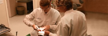 A dental hygiene student (left) receives hands-on training from her instructor (right).