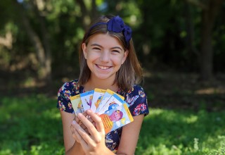 Eva holding her SUNCards that help kids through stressful situations