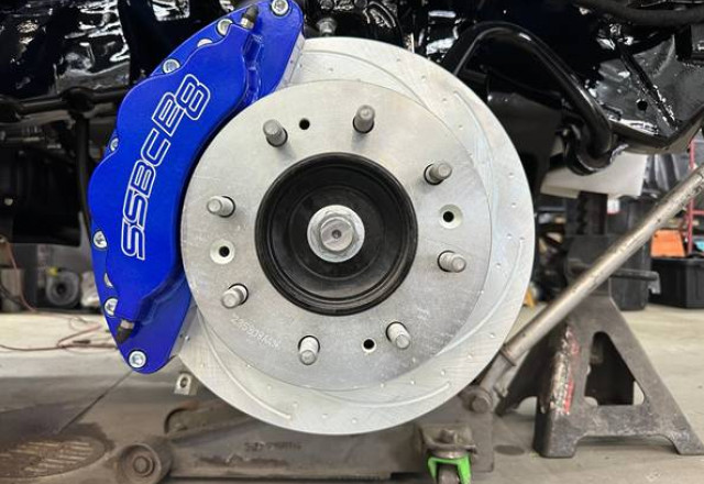 Blue SSBC B8 8-piston caliper mounted over a drilled and slotted rotor on the truck