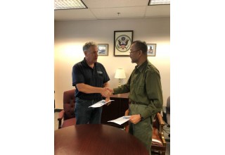 Capt. Edward Nanartowich shaking hands with Mr. Fernando M. Sopot and at the same time sharing each other's signed contract.