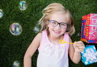 Essilor Vision Foundation young girl with glasses and bubbles
