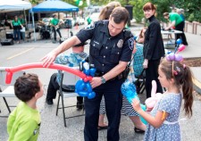 A policeman entertained two children with balloon art at the National Night Out block party at the Church of Scientology Seattle.