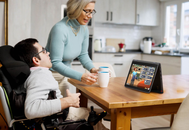 DD Waiver recipient and caregiver use Addison at kitchen table