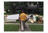 A Scientology Volunteer Minister carting debris out of a flood-damaged home