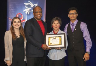 Dr. Sheridan Cyrus receives an award for his contributions to human rights education presented by Nicole Crellin, Youth for Human Rights Toronto Director accompanied by YHR volunteers Kristina Kisin and Abeir Liton. 