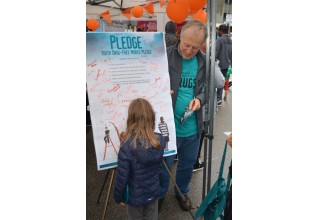 Youngster signs the drug-free pledge at the Drug-Free World booth at British Columbia Recovery Day Festival