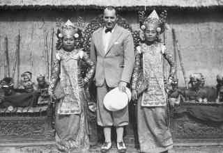 Robert Ripley standing with two Balinese dancers.